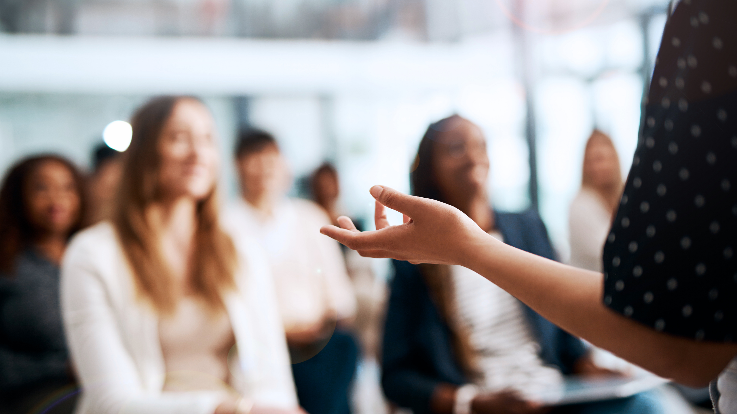 About The Summit Women listening to a female speaker